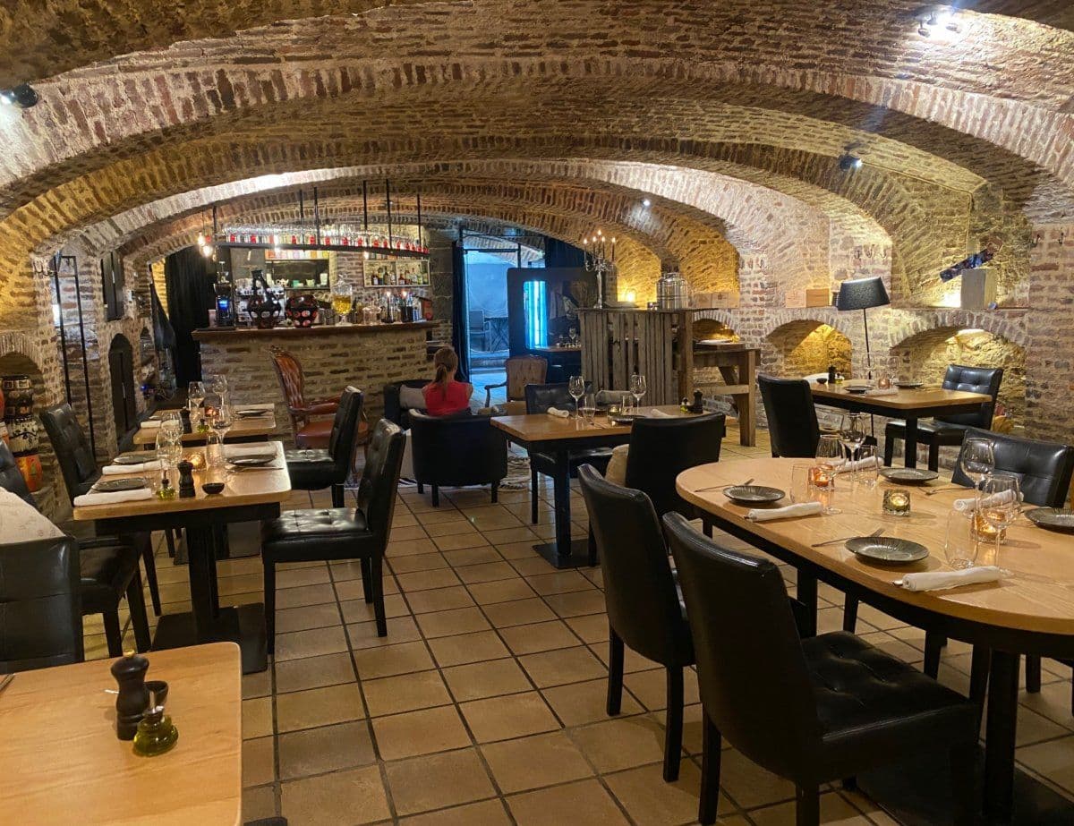 Vue d’ensemble de la cave voûtée du 16ᵉ siècle aménagée en salle de restaurant