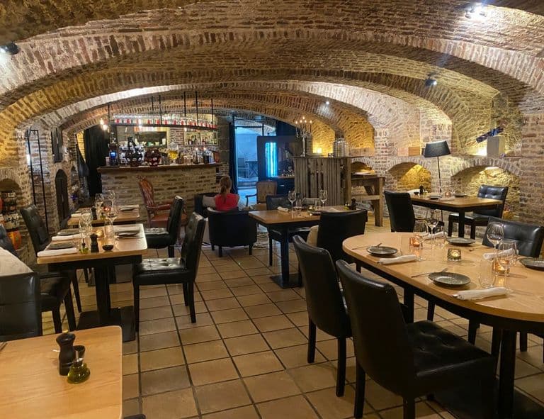 Vue d’ensemble de la cave voûtée du 16ᵉ siècle aménagée en salle de restaurant